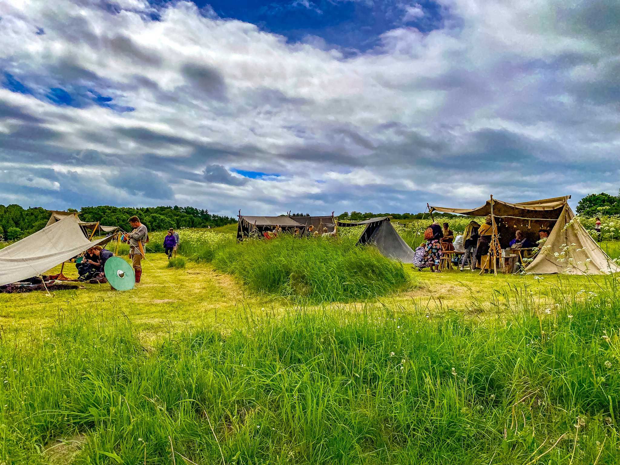 Telte med jernalderhåndværkere på græsmark